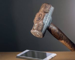Un martillo sobre la pantalla de un teléfono móvil